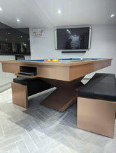 Load image into Gallery viewer, Convertible brushed copper pool table with blue felt and black bench seating.