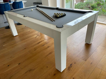 Gloss white pool dining table with black cloth in a modern dining room.