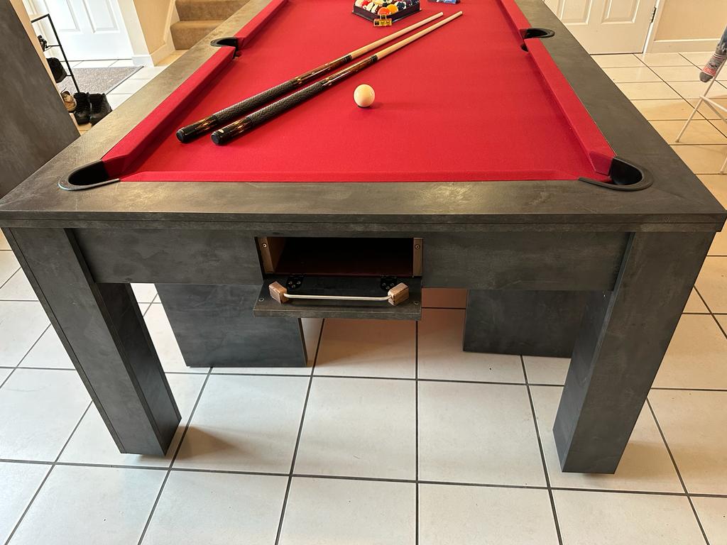 Close-up of pool dining table with red felt and built-in accessory drawer.