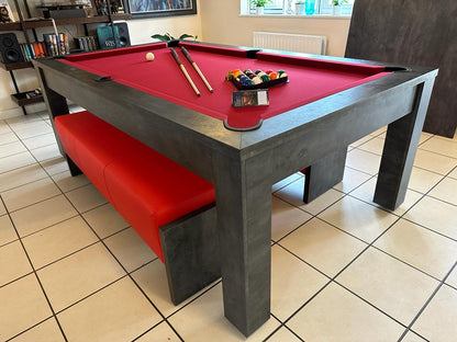 Modern pool dining table with red felt and matching red bench seating.