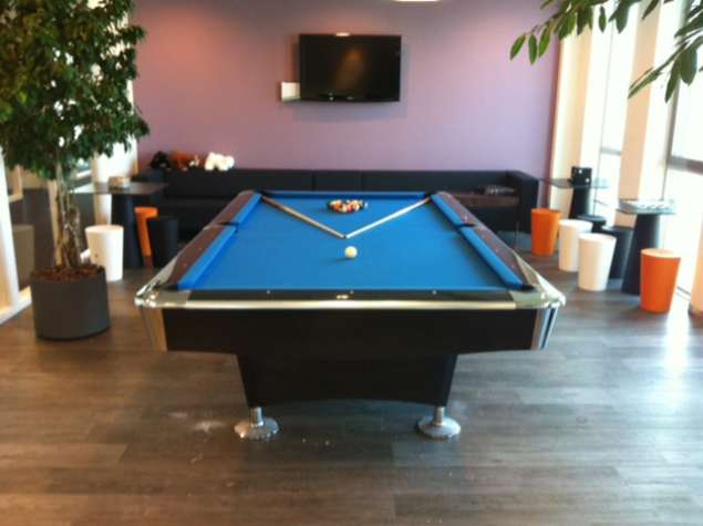 Modern American pool table with blue cloth in a stylish lounge area.