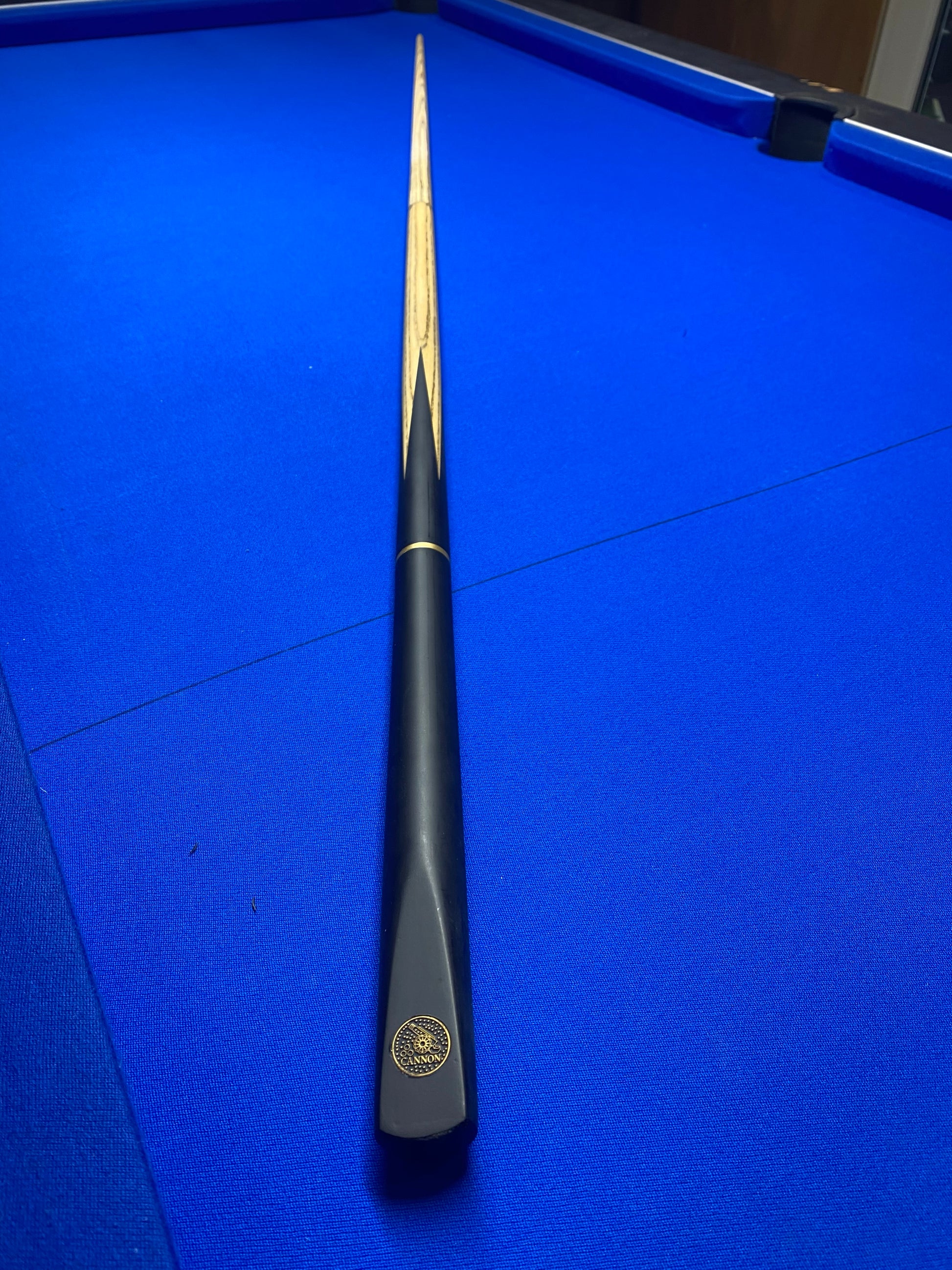 Fully assembled Cannon Manta 3 Piece 57-inch cue on a blue pool table.