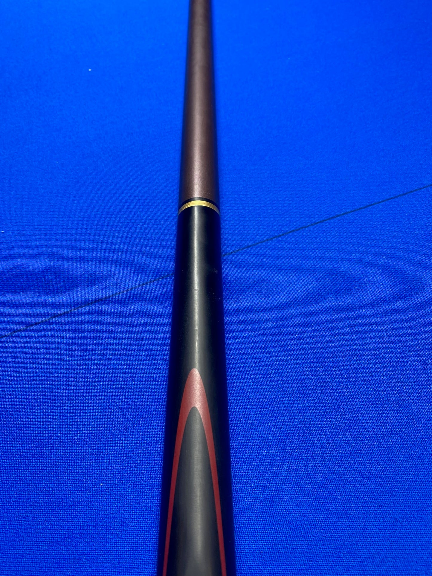 Close-up of Cannon Viper 3 Piece 57-inch cue handle on blue surface.