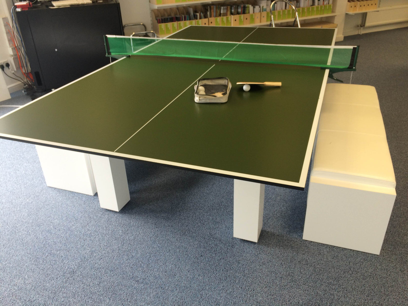 9' x 5' tournament standard table tennis top on a table with net and paddles.