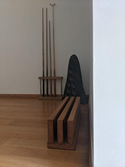 Pool cue rack and accessories placed against a wooden floor.