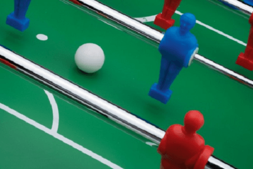 Close-up of Roberto Sport football table with red and blue players and white ball.