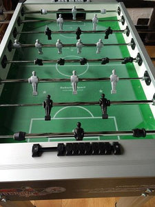 Top view of Roberto Sport football table with black and white players on a green playfield.