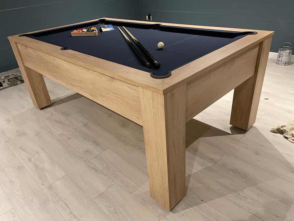 Nebraska Oak pool table with blue felt in a contemporary room with wood flooring.