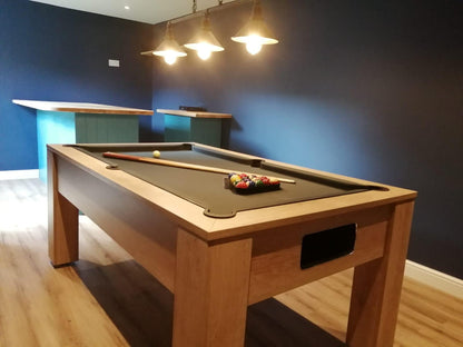 Classic oak pool table with green felt under stylish pendant lighting.