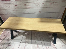 Load image into Gallery viewer, Cross leg pool dining table bench with a natural wood finish and black legs on a rustic floor.