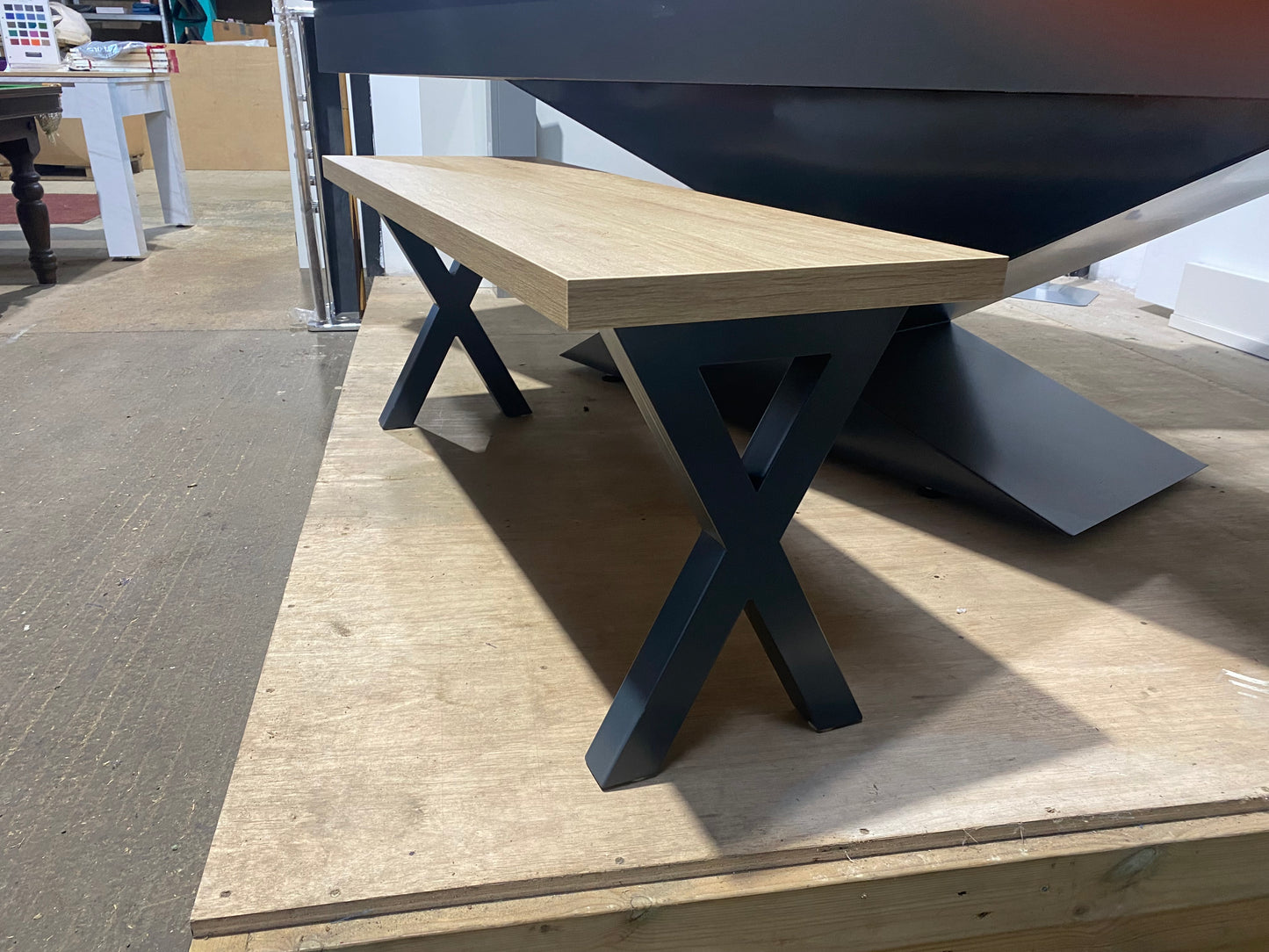 Angled view of the cross leg pool dining table bench highlighting its sturdy frame.