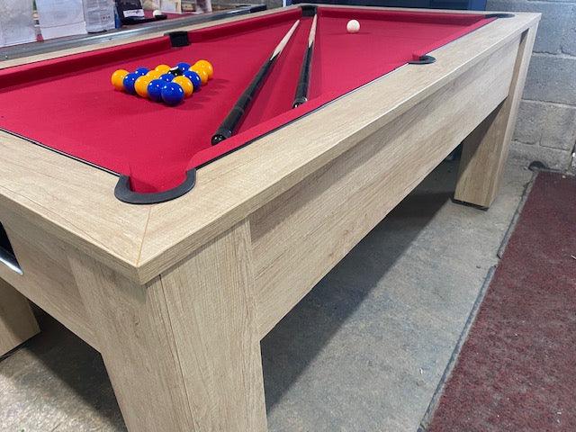 Red felt oak pool table with accessories and a sturdy wooden frame.
