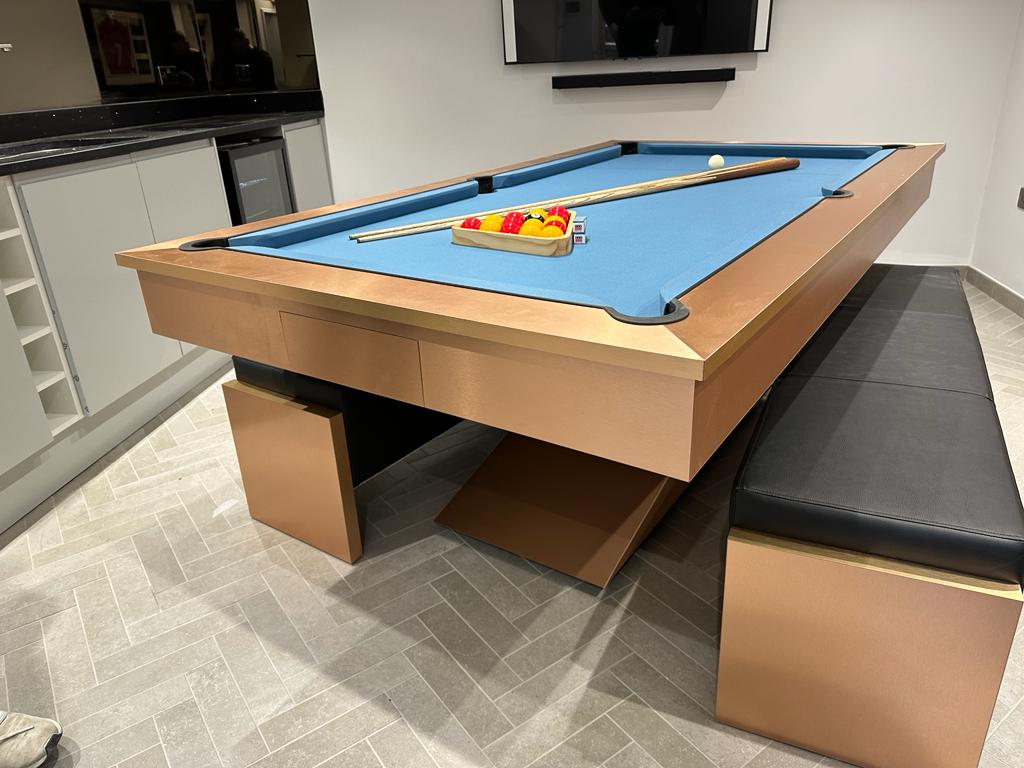 Brushed copper pool diner table with blue felt and matching benches.