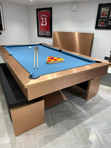 Stylish brushed copper pool table with blue playing surface and sleek design.