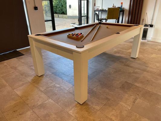Modern satin white Rosetta pool dining table with tan felt in a bright room.