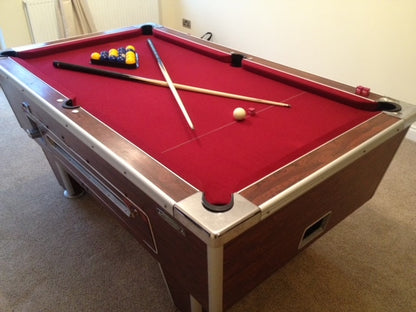 Reconditioned 7' x 4' Rosewood Superleague pool table with red felt and cues placed on top.
