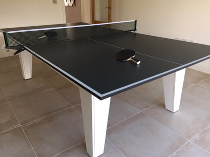 8' x 4' table tennis top with net and paddle on a tiled surface.
