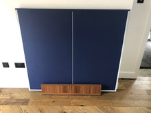 Load image into Gallery viewer, Folded table tennis top in blue with a wooden base for easy storage.