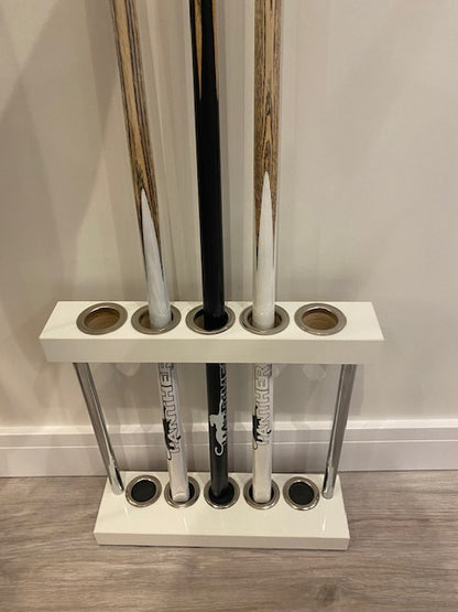 White Superpool Match Cue Stand placed against a wall, holding 5 cues.